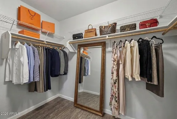 a view of walk in closet with clothes and shoes