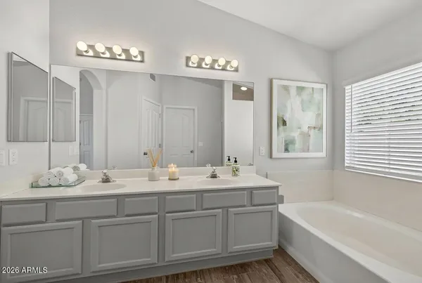 a bathroom with a sink double vanity granite tub and a mirror