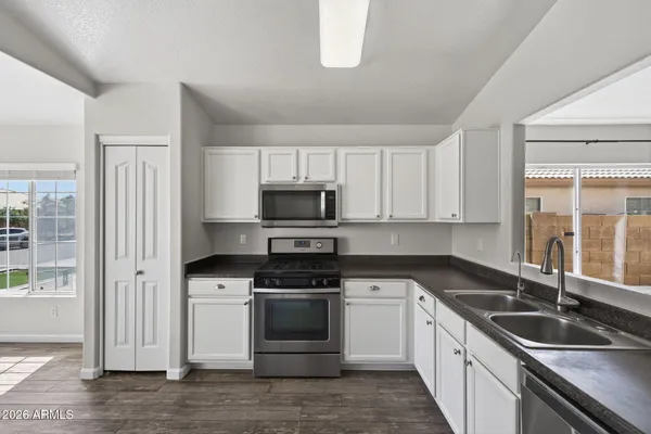 a kitchen with granite countertop a sink and steel appliances