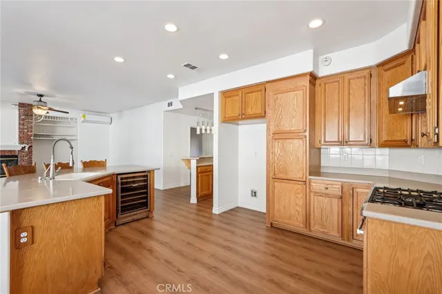 a kitchen with stainless steel appliances granite countertop a refrigerator a stove and a sink with wooden floors