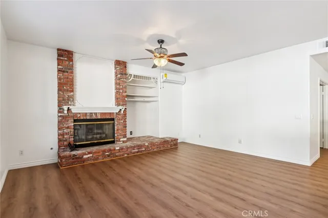 a view of an empty room with a fireplace and a window