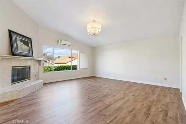 a view of an empty room with a fireplace and a window