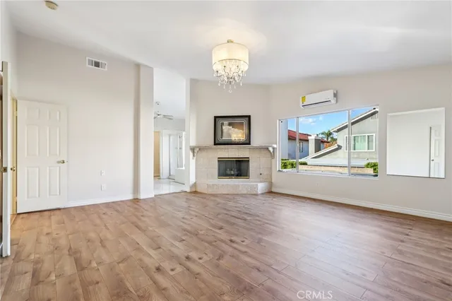 a view of an empty room with a fireplace and a window