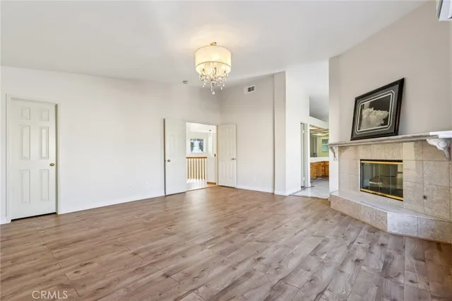 a view of empty room with wooden floor and fireplace