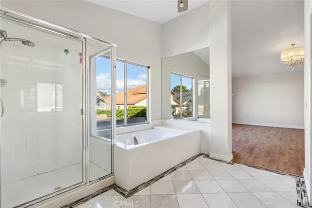 a spacious bathroom with a tub shower and mirror
