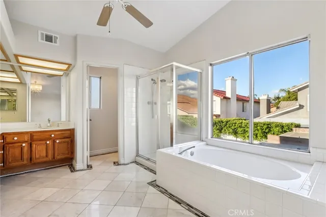 a bathroom with a tub a sink and a large mirror