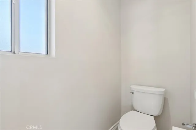 a white toilet sitting next to a white wall