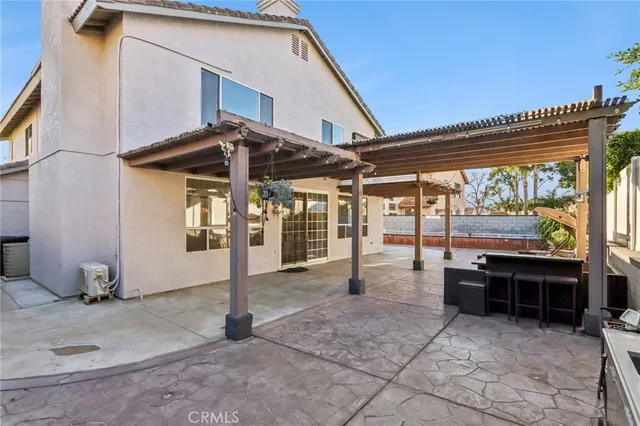 a view of a patio with a table and chairs under an umbrella with a large tree