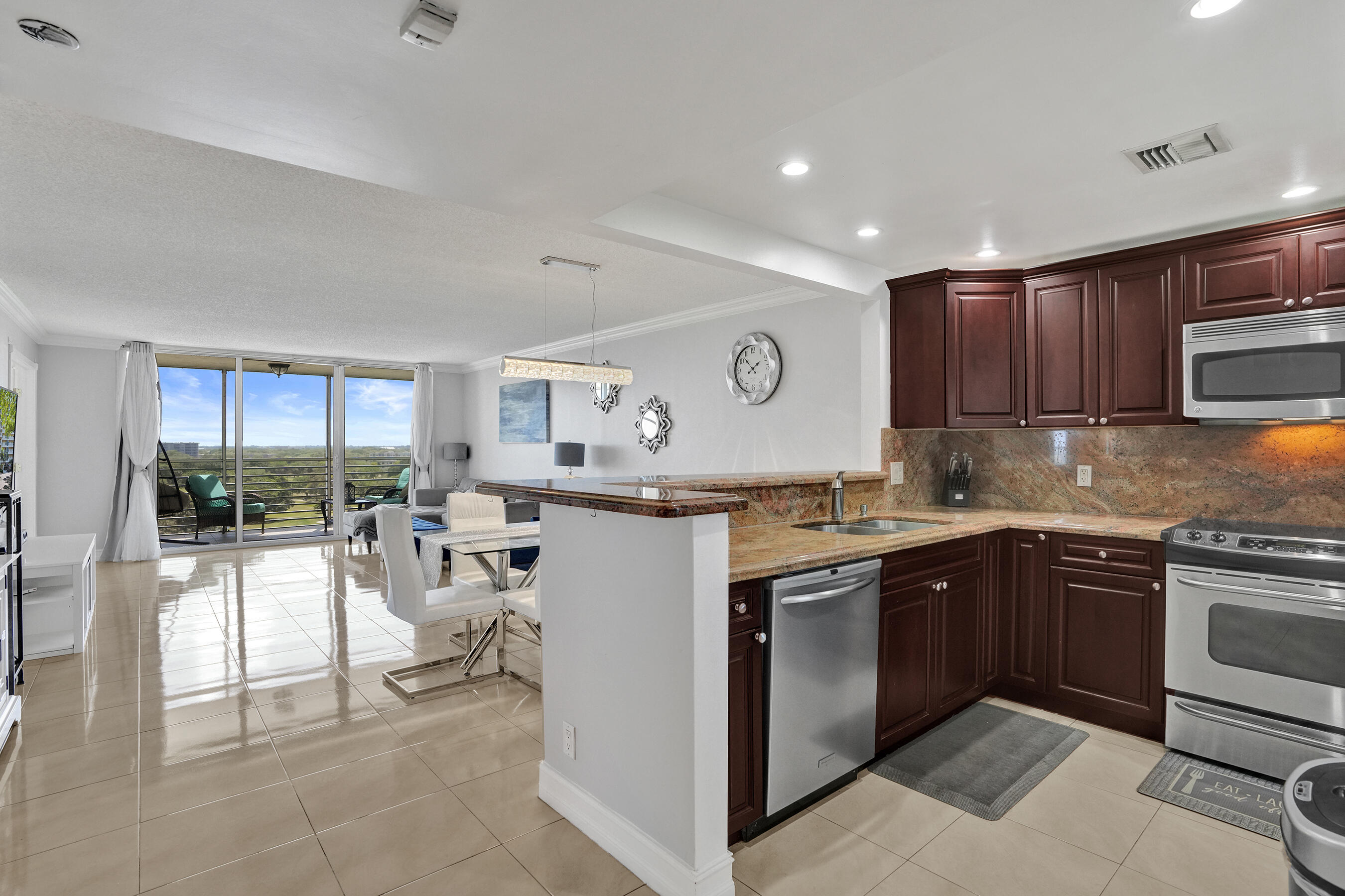 3520 Oaks Way, Unit 1010 Pompano Beach, FL 33069 - Photo 12 of 67 a kitchen with a sink a counter top space and appliances