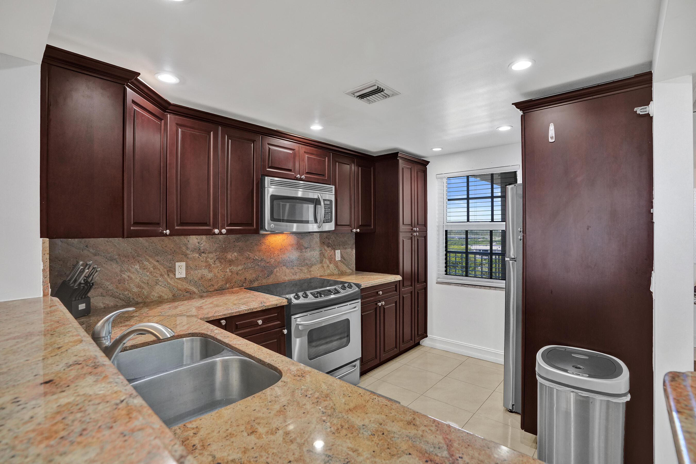3520 Oaks Way, Unit 1010 Pompano Beach, FL 33069 - Photo 13 of 67 a kitchen with stainless steel appliances granite countertop a sink a stove and a refrigerator