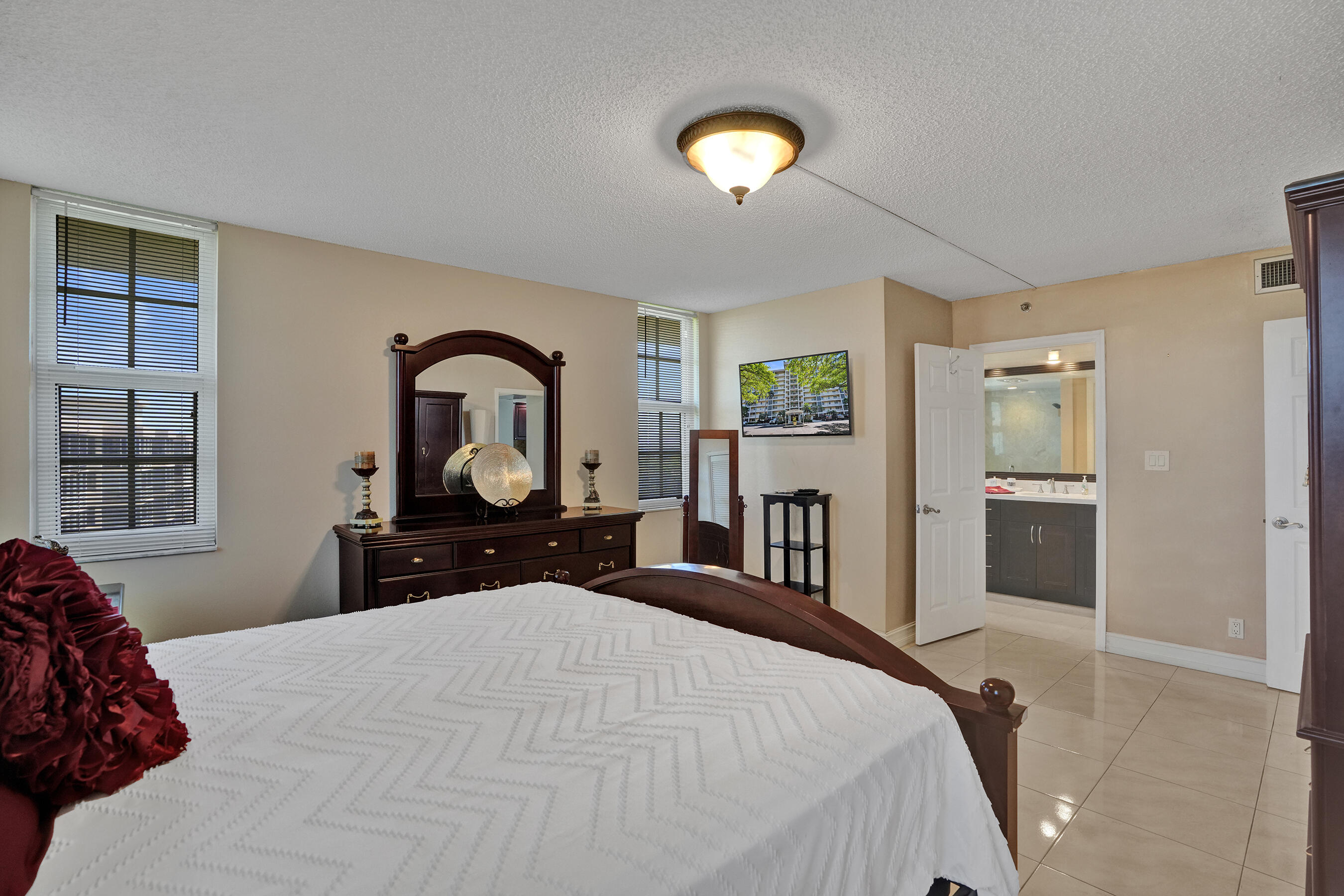 3520 Oaks Way, Unit 1010 Pompano Beach, FL 33069 - Photo 18 of 67 a bedroom with a bed and a large mirror