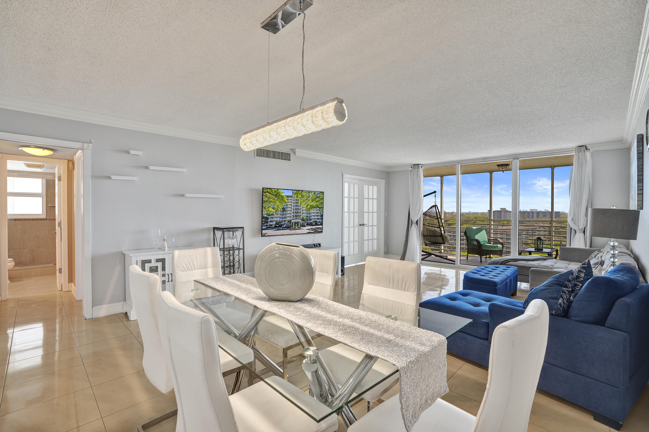 3520 Oaks Way, Unit 1010 Pompano Beach, FL 33069 - Photo 25 of 67 a living room with furniture a wooden floor and a chandelier