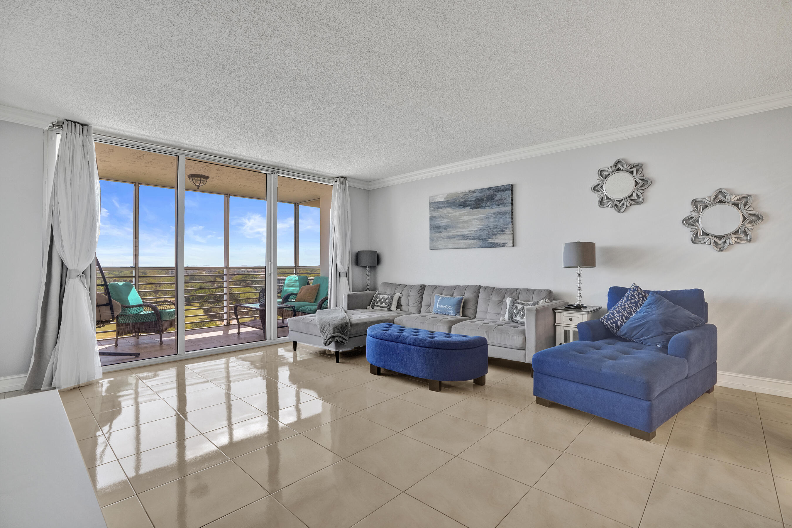 3520 Oaks Way, Unit 1010 Pompano Beach, FL 33069 - Photo 27 of 67 a living room with furniture and a floor to ceiling window