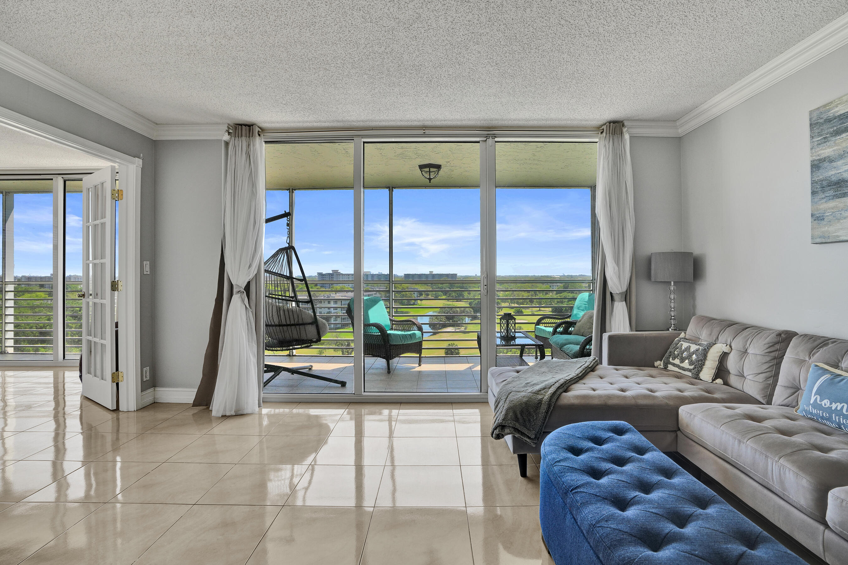 3520 Oaks Way, Unit 1010 Pompano Beach, FL 33069 - Photo 28 of 67 a living room with furniture and a floor to ceiling window