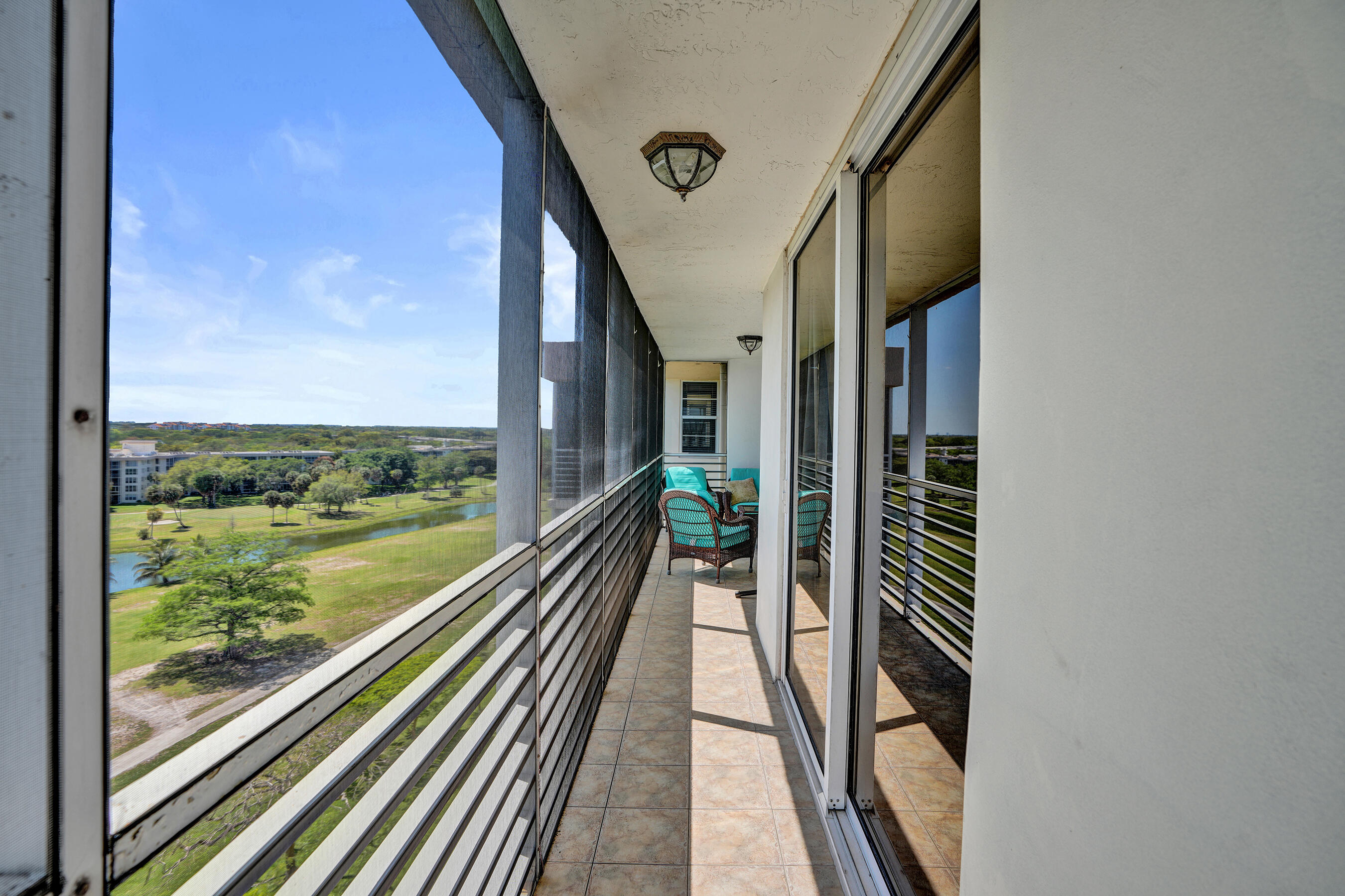 3520 Oaks Way, Unit 1010 Pompano Beach, FL 33069 - Photo 32 of 67 a view of a balcony with floor to ceiling windows with wooden floor