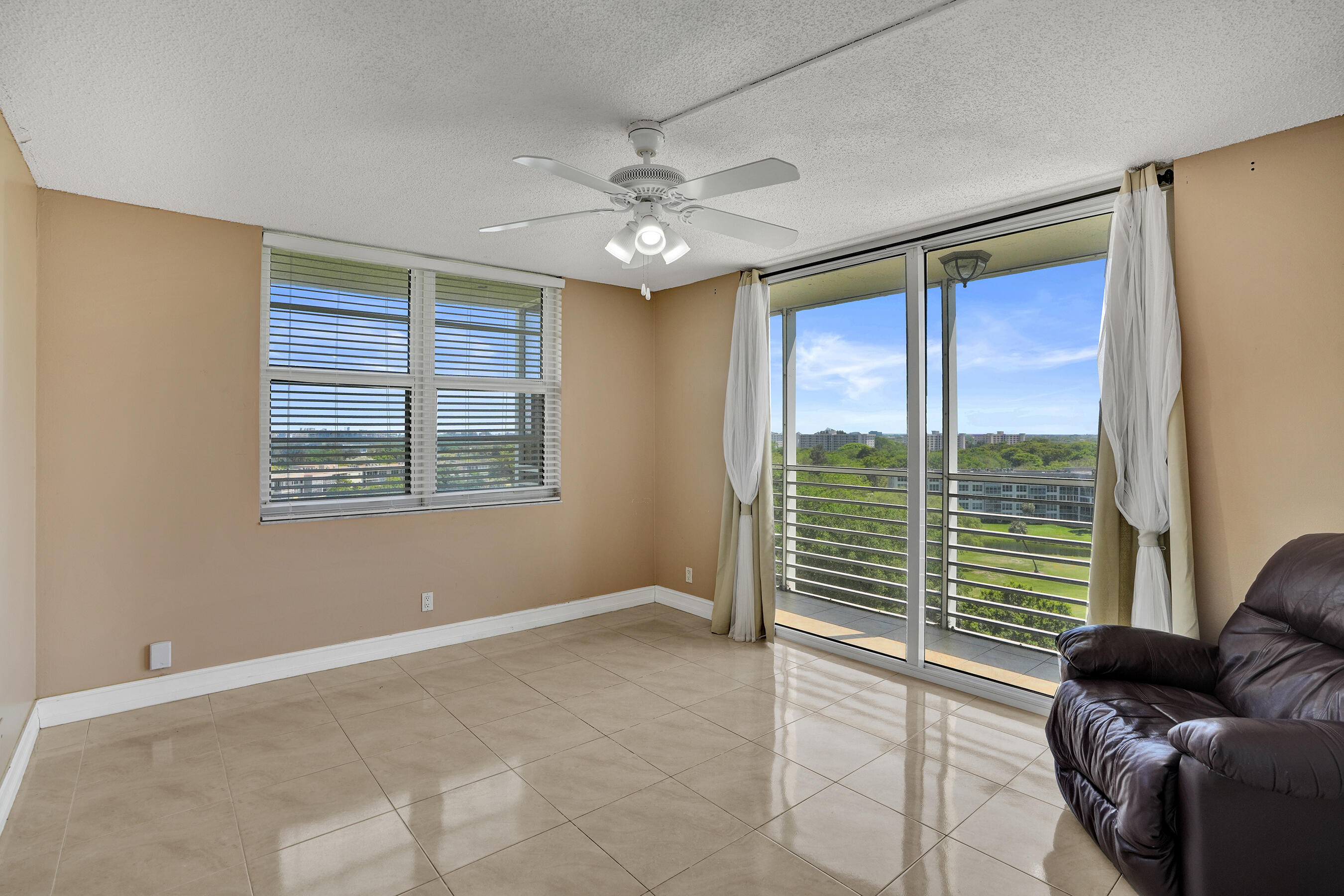 3520 Oaks Way, Unit 1010 Pompano Beach, FL 33069 - Photo 38 of 67 a view of a livingroom with a large window and couch
