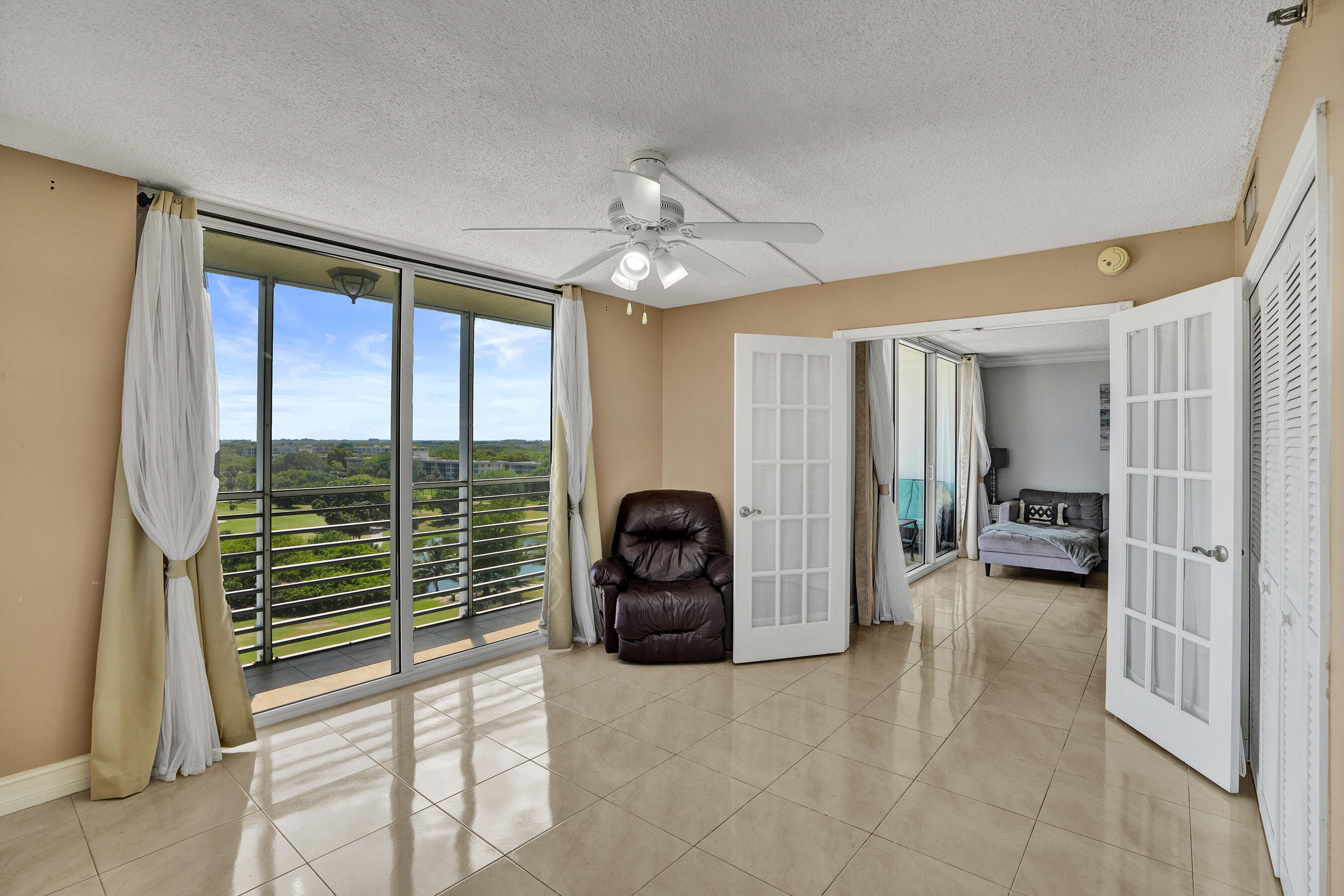 3520 Oaks Way, Unit 1010 Pompano Beach, FL 33069 - Photo 41 of 67 a view of a livingroom with furniture and floor to ceiling window