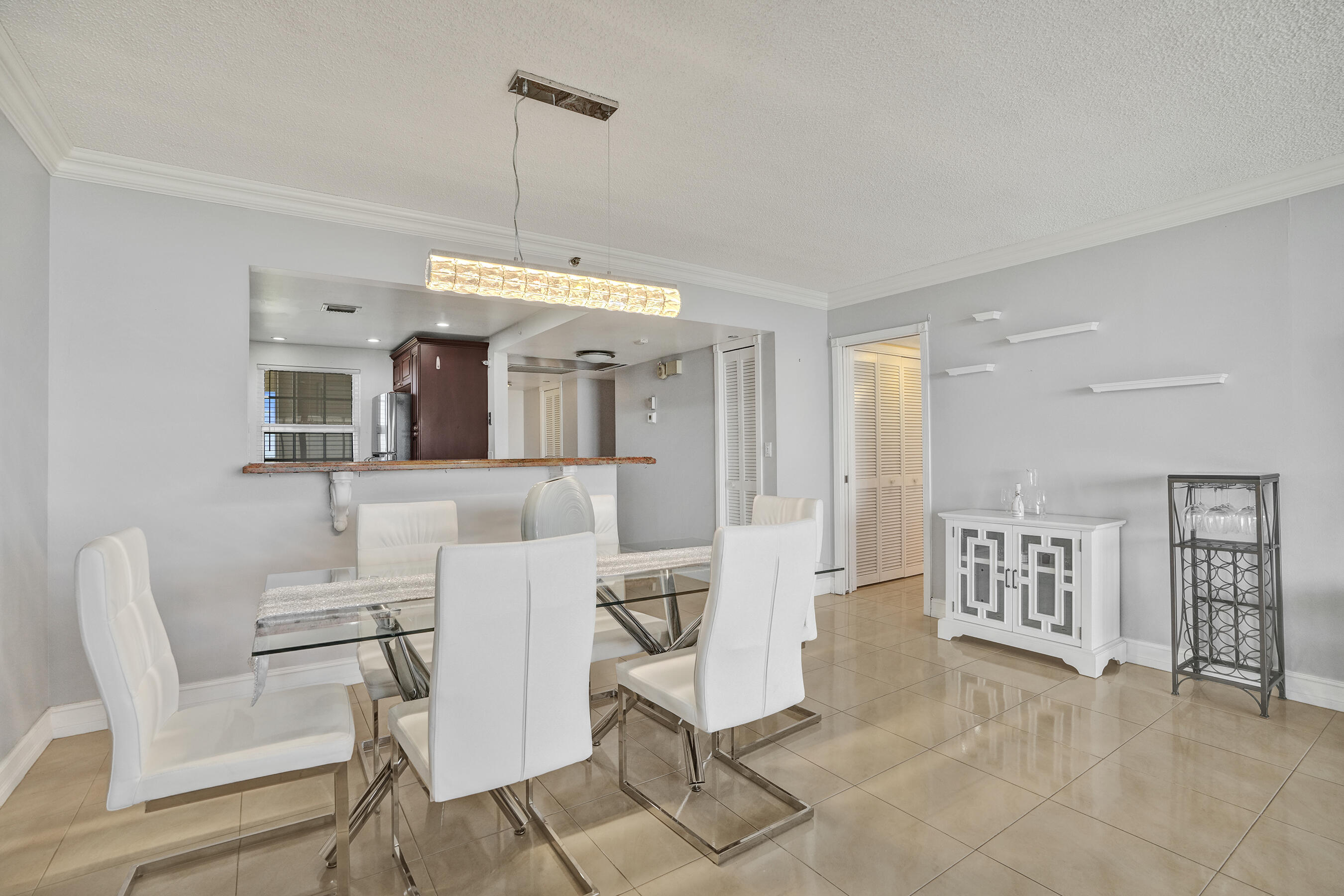 3520 Oaks Way, Unit 1010 Pompano Beach, FL 33069 - Photo 44 of 67 a living room with furniture a dining table and a chandelier