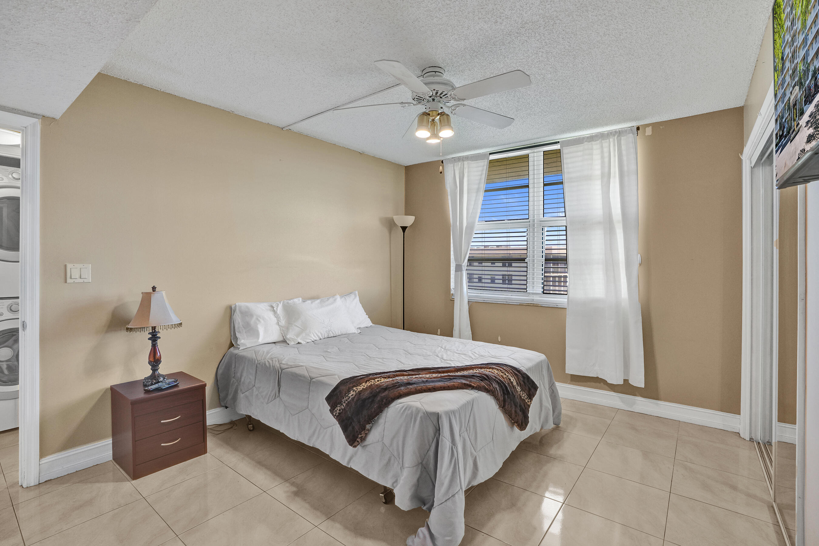 3520 Oaks Way, Unit 1010 Pompano Beach, FL 33069 - Photo 49 of 67 a bedroom with a large bed and a chandelier