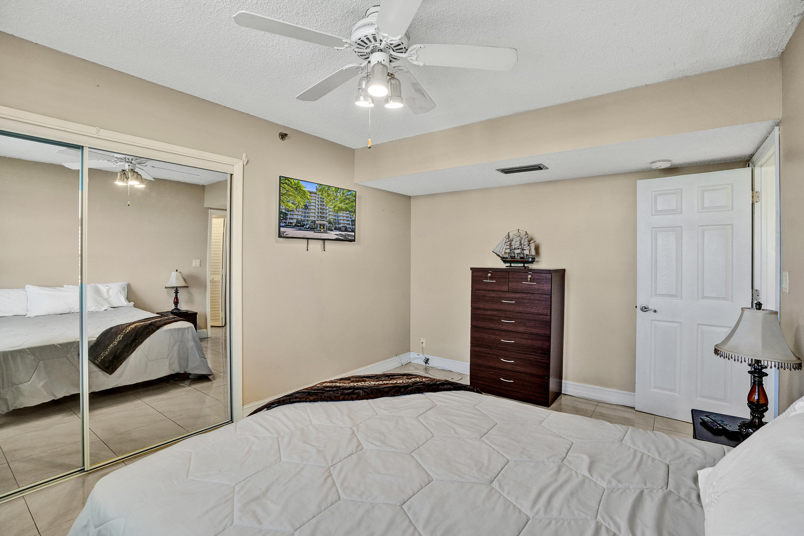 3520 Oaks Way, Unit 1010 Pompano Beach, FL 33069 - Photo 50 of 67 a bedroom with a bed and a chandelier