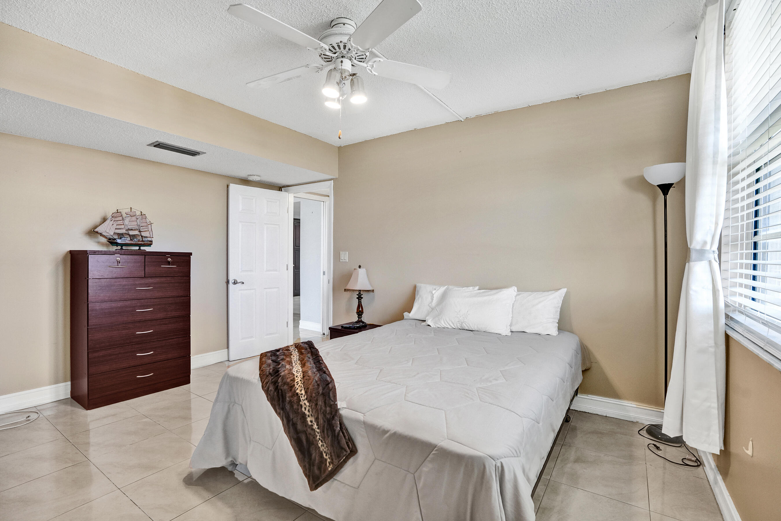 3520 Oaks Way, Unit 1010 Pompano Beach, FL 33069 - Photo 51 of 67 a bedroom with a bed and a dresser