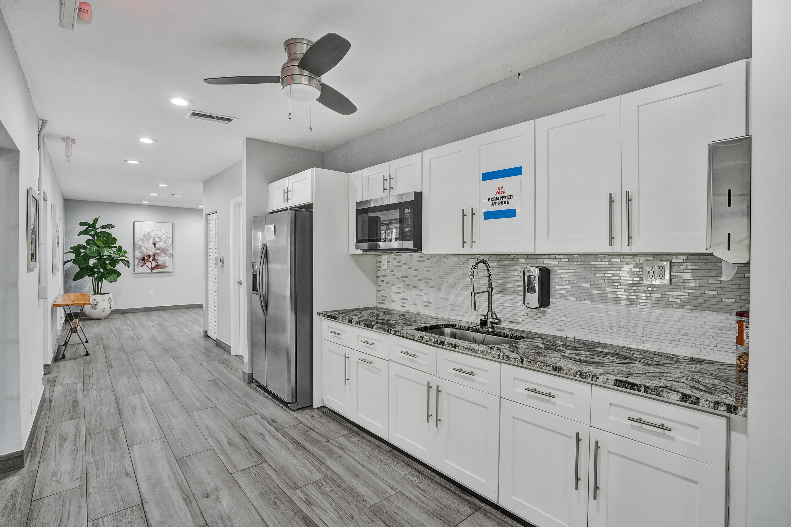 3520 Oaks Way, Unit 1010 Pompano Beach, FL 33069 - Photo 63 of 67 a kitchen with kitchen island granite countertop a sink cabinets and stainless steel appliances