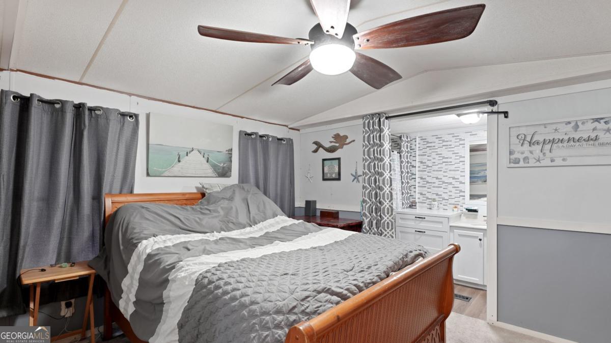 4866 Kville Road Screven, GA 31560 - Photo 23 of 39 a bedroom with a large bed and a chandelier