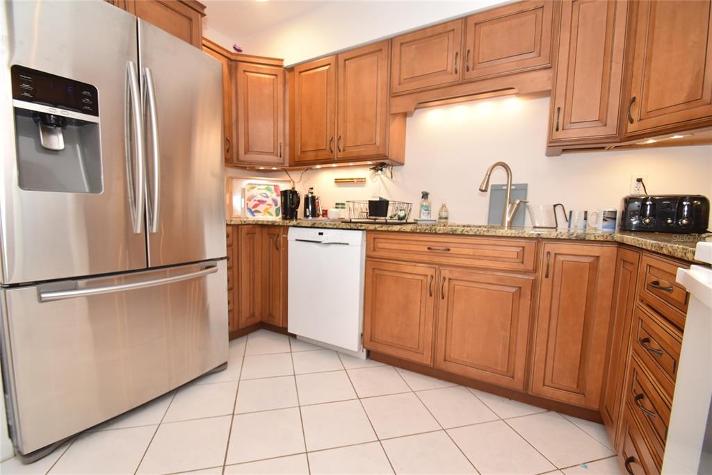 1512 Pelican Point Drive, Unit BA264 Sarasota, FL 34231 - Photo 6 of 44 a kitchen with stainless steel appliances granite countertop a refrigerator sink and cabinets
