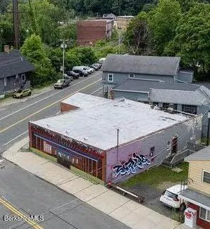 an aerial view of a house with swimming pool and a yard