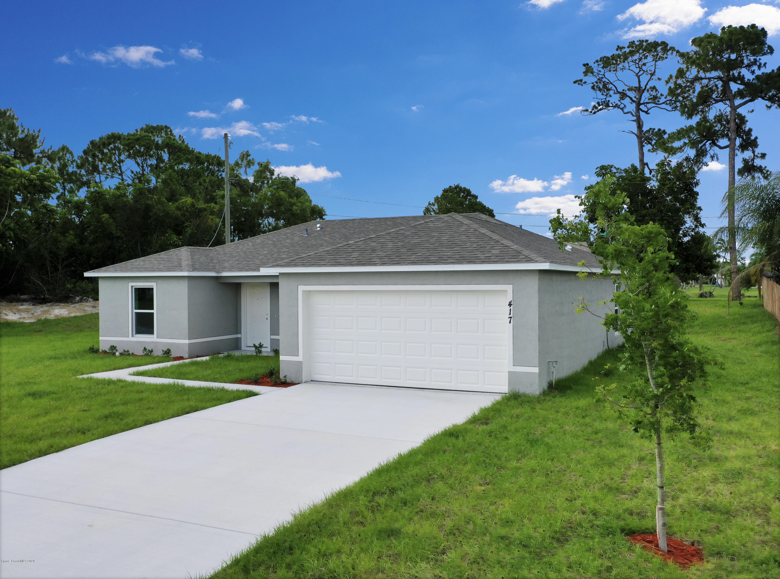 1237 Haulover Road Southwest Palm Bay, FL 32908 - Photo 2 of 15 a front view of a house with a yard and garage