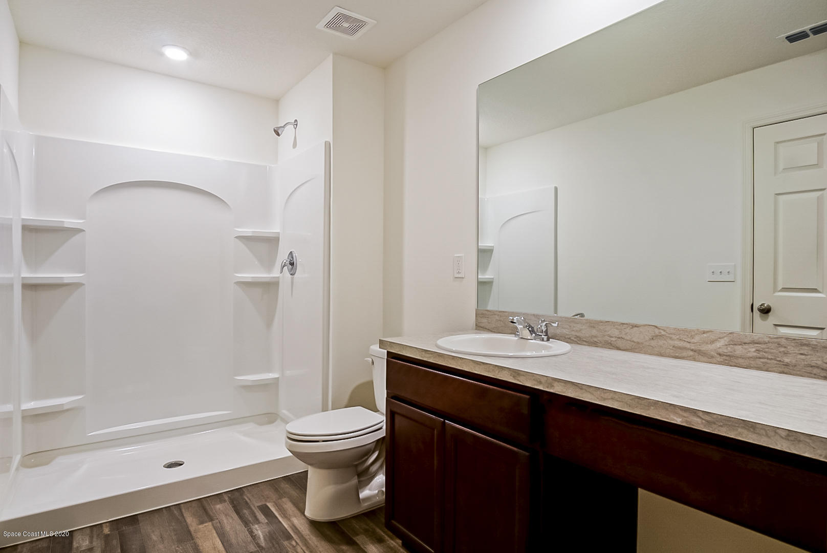1237 Haulover Road Southwest Palm Bay, FL 32908 - Photo 7 of 15 a bathroom with a granite countertop sink toilet a large mirror a bathtub and shower