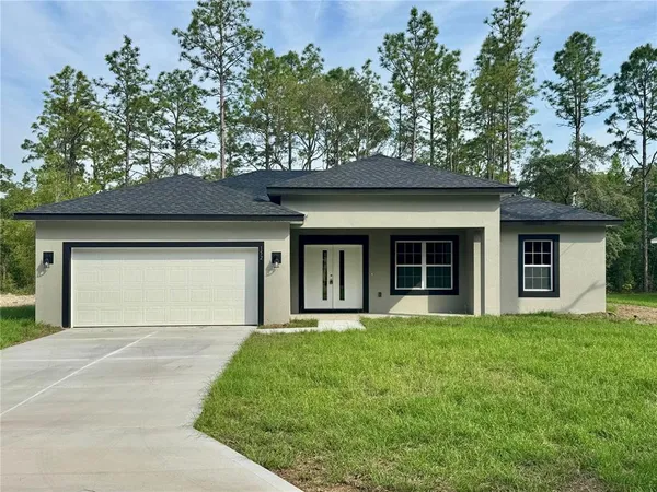 a front view of a house with yard and trees
