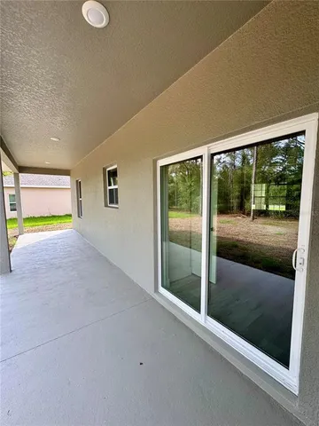a view of an empty room with floor to ceiling windows