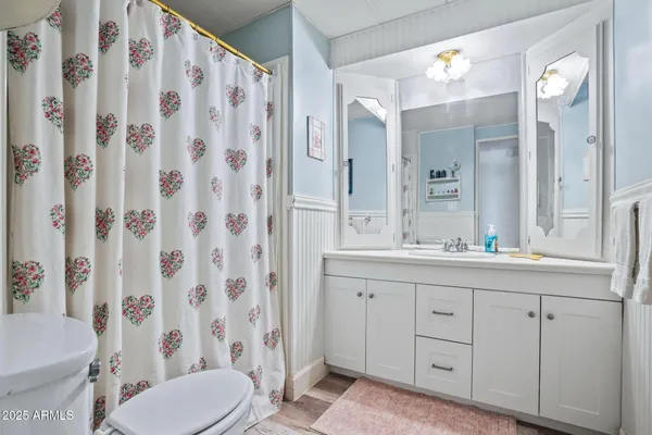 a bathroom with a granite countertop sink a toilet and a mirror