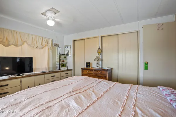 a bedroom with a bed and a flat screen tv