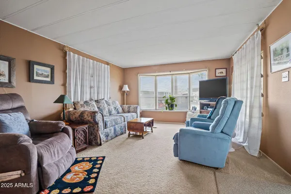 a living room with furniture flat screen tv and a window