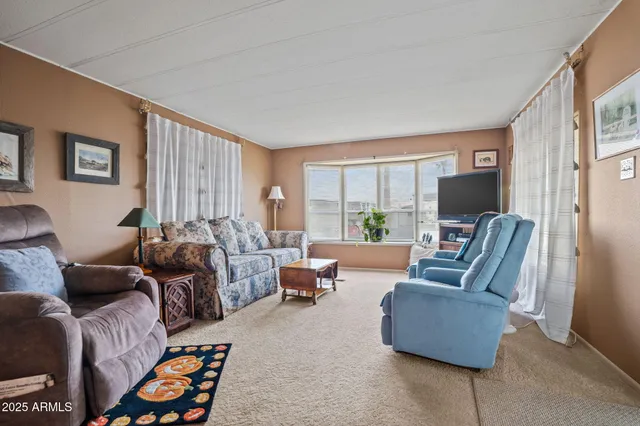 a living room with furniture flat screen tv and a window