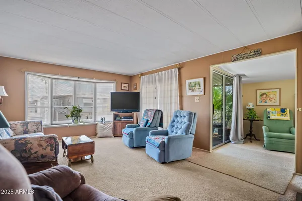 a living room with furniture a large window and a flat screen tv