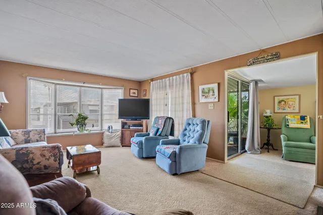 a living room with furniture a large window and a flat screen tv