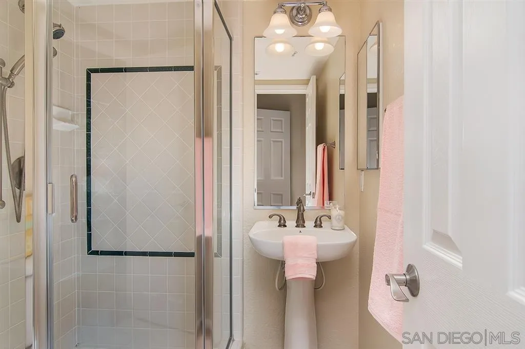2230 Historic Decatur Road, Unit 63 San Diego, CA 92106 - Photo 17 of 25 a bathroom with a sink a mirror and shower