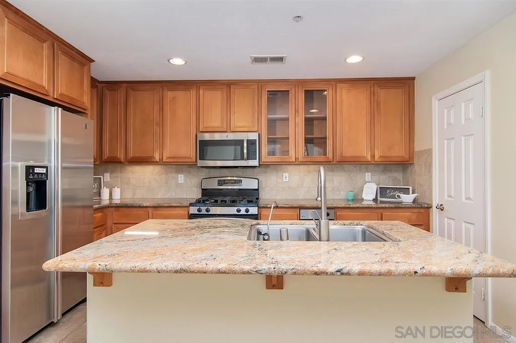 2230 Historic Decatur Road, Unit 63 San Diego, CA 92106 - Photo 5 of 25 a kitchen with stainless steel appliances granite countertop a sink stove and refrigerator