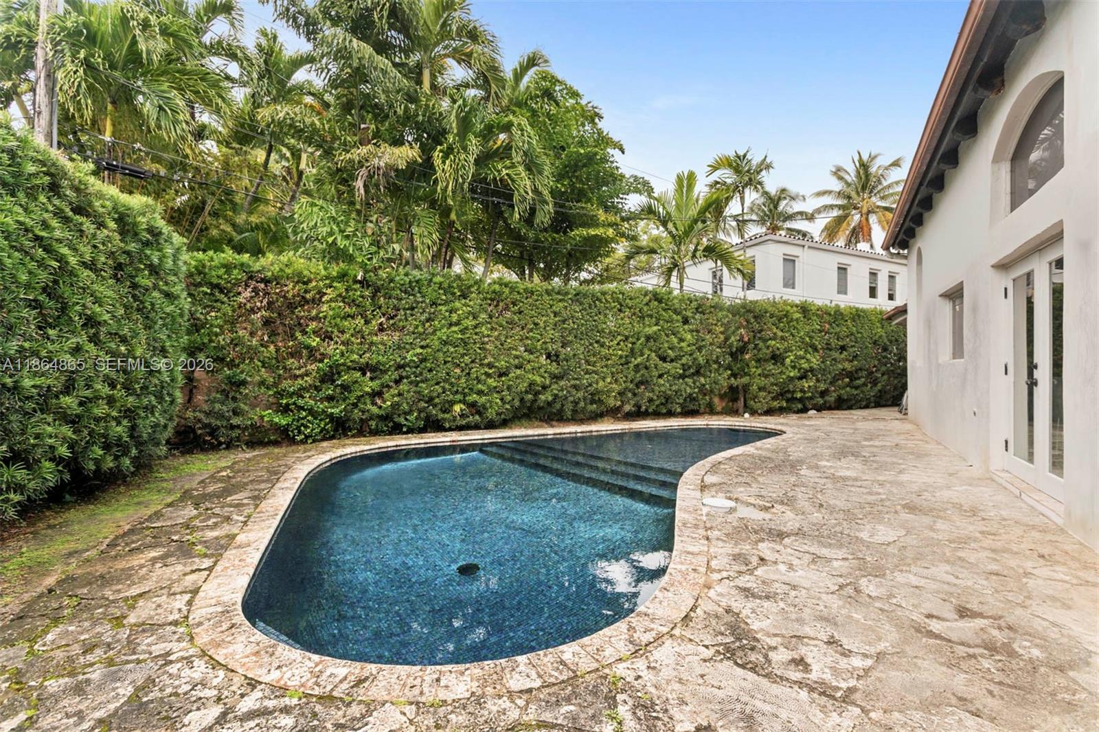 6350 Pine Tree Drive Miami Beach, FL 33140 - Photo 12 of 32 a view of a swimming pool in the backyard