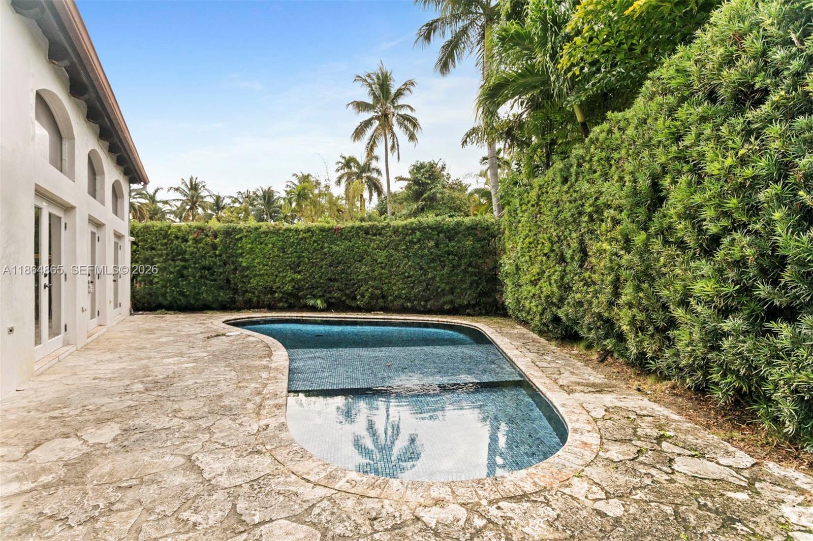6350 Pine Tree Drive Miami Beach, FL 33140 - Photo 13 of 32 a view of a swimming pool with a yard