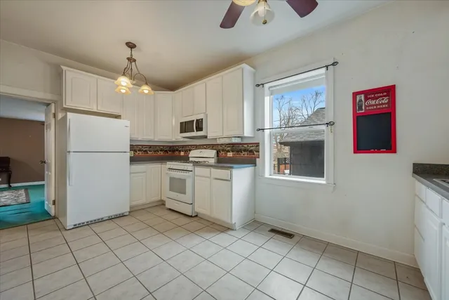 a kitchen with white cabinets a sink and white appliances