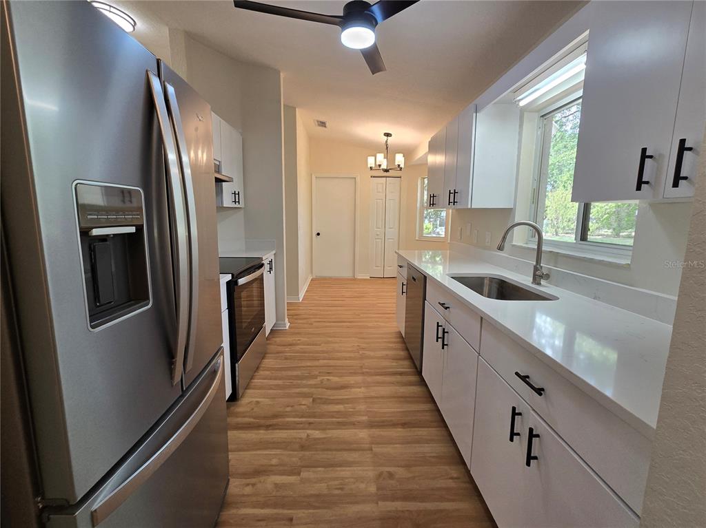 6121 Southwest 103rd Loop Ocala, FL 34476 - Photo 14 of 32 a large white kitchen with sink and stainless steel appliances