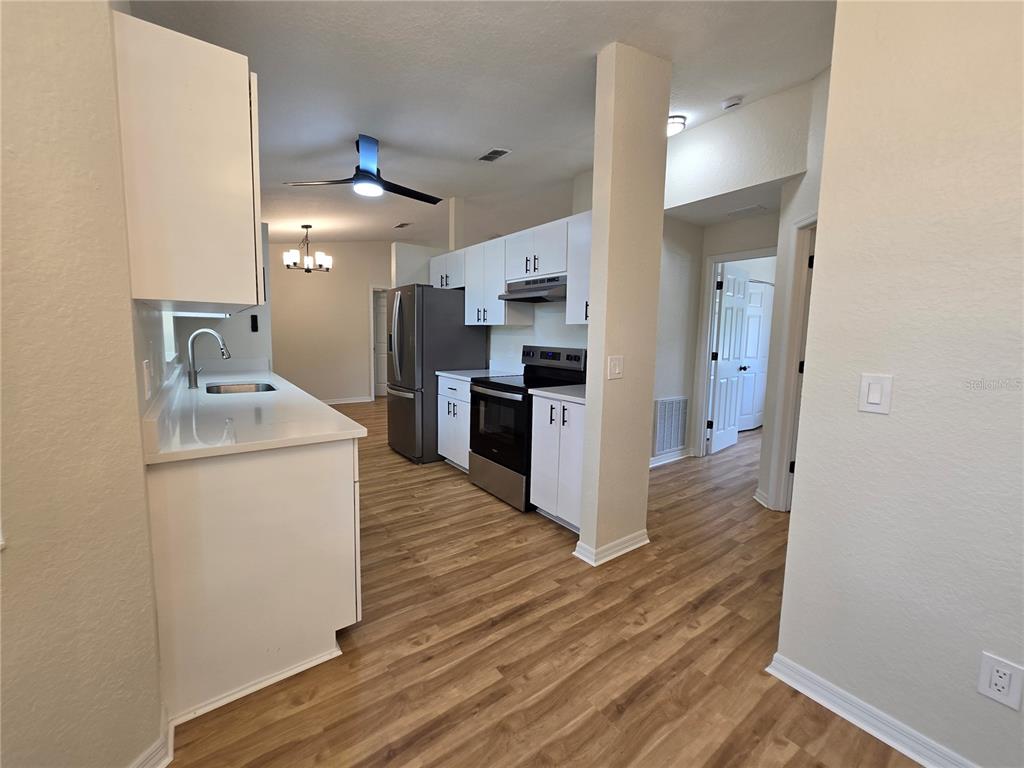 6121 Southwest 103rd Loop Ocala, FL 34476 - Photo 17 of 32 a open kitchen with a sink and refrigerator