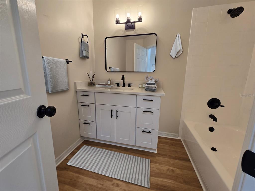 6121 Southwest 103rd Loop Ocala, FL 34476 - Photo 18 of 32 a bathroom with a sink a mirror and shower