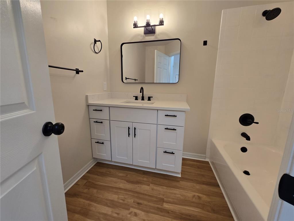 6121 Southwest 103rd Loop Ocala, FL 34476 - Photo 19 of 32 a bathroom with a sink a mirror and shower