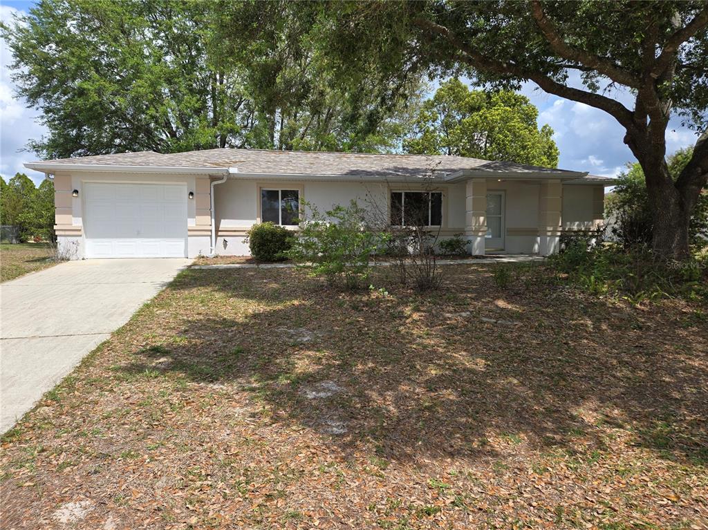 6121 Southwest 103rd Loop Ocala, FL 34476 - Photo 2 of 32 a front view of house with yard and trees in the background