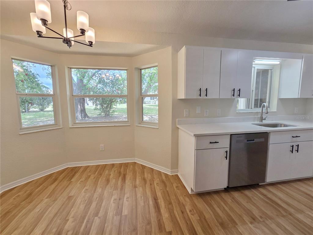 6121 Southwest 103rd Loop Ocala, FL 34476 - Photo 23 of 32 a kitchen with a wooden floor window and cabinets